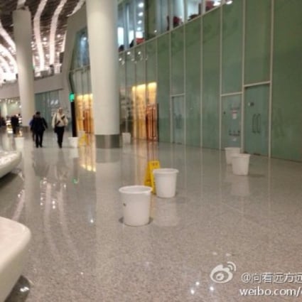 Screengrab from Weibo showing janitors putting buckets on the floor to collect leaking water in the terminal building
