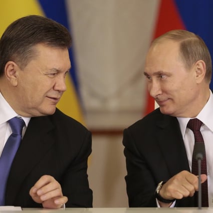 Russian President Vladimir Putin (right) and his Ukrainian counterpart Viktor Yanukovych smile after signing a bailout agreement in Moscow on Tuesday. Photo: EPA