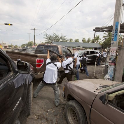 Men belonging to the Self-Defense Council of Michoacan (CAM), engage in a firefight while trying to flush out alleged members of the Knights Templar drug cartel. Photo: AP