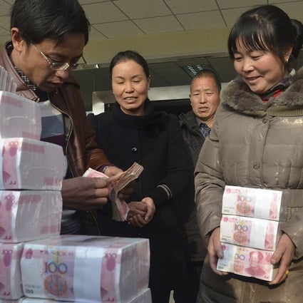 Ling Xuxia collects her 314,000 yuan year-end bonus at Jianshe village. Photo: Reuters