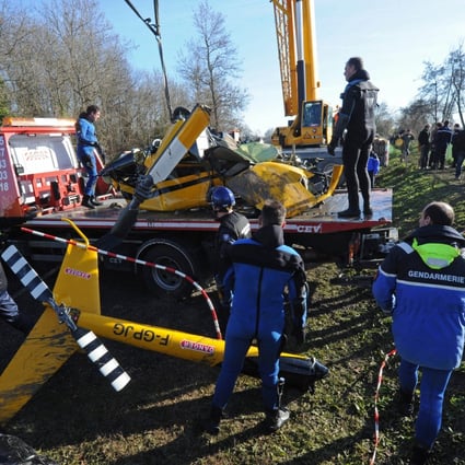 Gendarmes inspect the wreckage of the crashed Robinson R44 helicopter in Lugon-et-l'Ile-du-Carnay, southwestern France, on December 23, 2013 after they lifted it from the Dordogne river bed. Photo: AFP