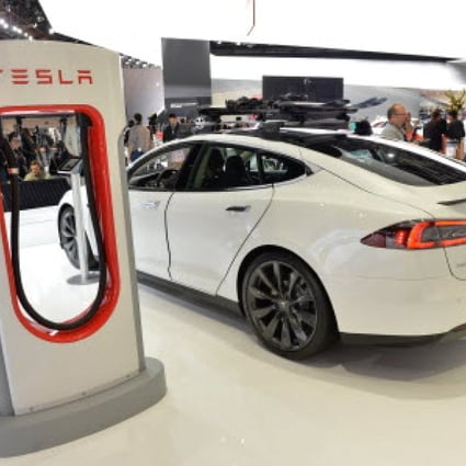 A Tesla electric car and a charging station, displayed at an American automotive show. Photo: AFP