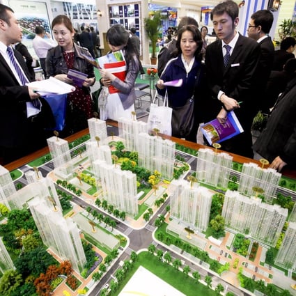 Buyers look at models of new residential developments for sale in Beijing. Home prices in Beijing and three other major cities rose more than 20 per cent in November. Photo: EPA