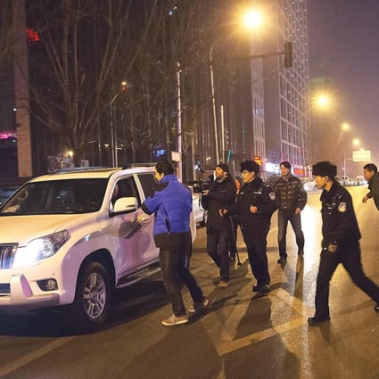 Policemen rush to prevent journalists to interview Zhang Qingfang, the lawyer of Xu Zhiyong, near the No. 1 Intermediate People's Court, where Xu stood trial, in Beijing Wednesday. Photo: AP