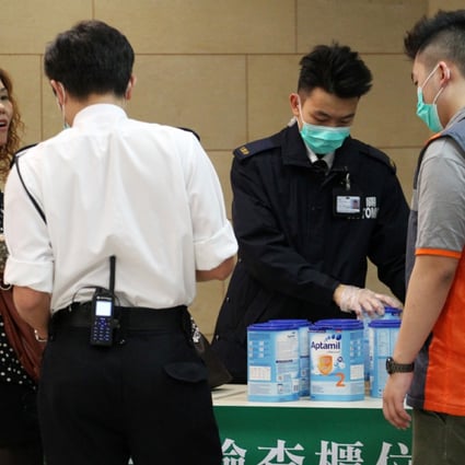 Customs officials inspect excess amount of milk powder carry by a traveller in Lo Wu.