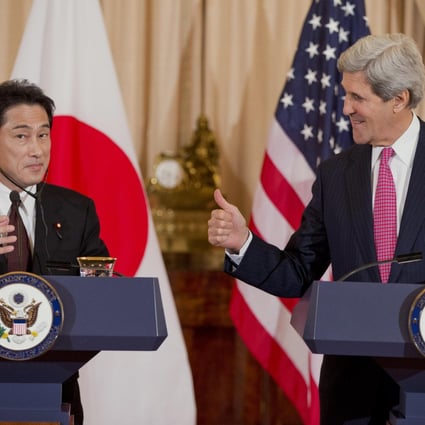 Secretary of State John Kerry checks whether Japanese Foreign Minister Fumio Kishida is receiving his message at a press conference in Washington. Photo: AP