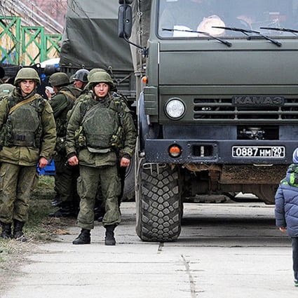 Russian military personnel enter the eastern Crimean port city of Feodosiya. Photo: AFP