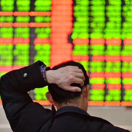 An investor scratches his head while watching stock information in a trading hall of a securities firm in Shanghai on March 10, 2014. Photo: Xinhua