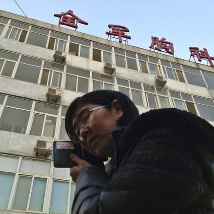 Wang Yu, the lawyer of human right activist Cao Shunli, talked on the phone in front of a hospital building where Cao was hospitalized in Beijing. Photo: Reuters