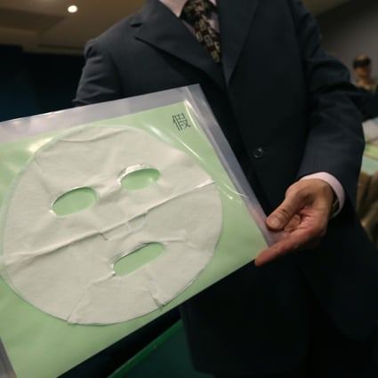 A customs officer displays a sample of the counterfeit My Beauty Diary cosmetic masks seized in the raid. Photo: David Wong