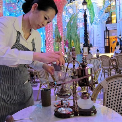 An MGM Macau staff member grinds "elephant dung" coffee beans by hand before serving up the rarefied brew. Photo: Lana Lam