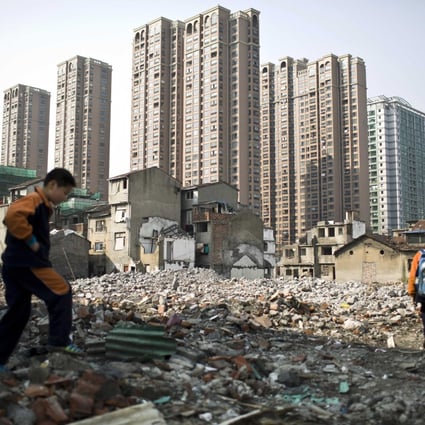 Pupils walk in an area where old residential buildings are being demolished to make room for new skyscrapers in downtown Shanghai, March 14, 2014. Photo: Reuters