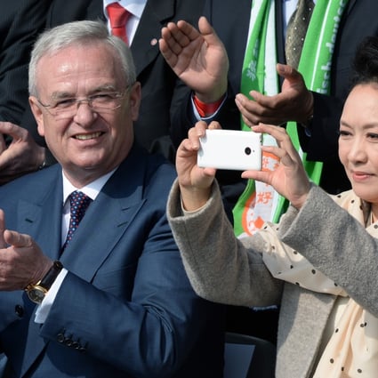 Peng Liyuan, wife of the president of the People's Republic of China, Xi Jinping, takes pictures next to Volkswagen CEO, Martin Winterkorn in Berlin, Germany on Saturday. Photo: AP