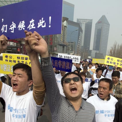 Chinese relatives of passengers on board the missing Malaysia Airlines flight MH370 shout in protest as they march towards the Malaysia embassy in Beijing. Photo: AP