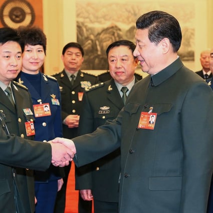 Chinese President Xi Jinping talks with a deputy to the 12th National People's Congress (NPC) from the People's Liberation Army (PLA) in Beijing on March 11. Photo: Xinhua