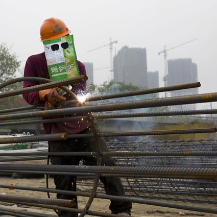 A welder improvises his mask at a site in Zhejiang province. Steel output growth is seen slowing to 3 per cent this year. Photo: Reuters