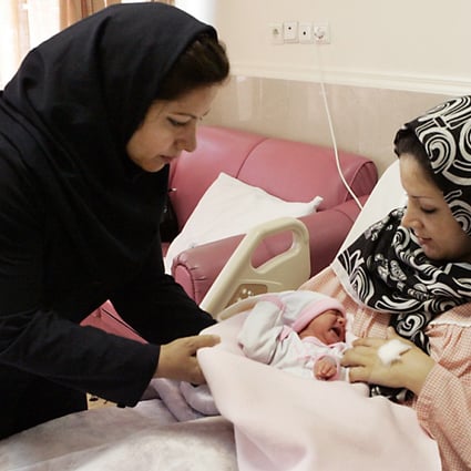 Iranian nurse gives one-day-old baby girl Setayesh to her mother at the Mehr hospital in Tehran. Photo: AP