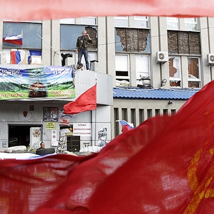 Pro-Russian protesters stand at the seized office of the SBU state security service in Luhansk, eastern Ukraine. Photo: Reuters