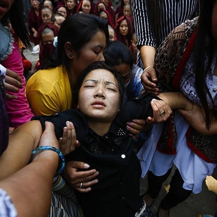 The daughter of Ang Kaji Sherpa, one of the victims of the Mount Everest avalanche, collapses during his cremation ceremony. Photo: EPA