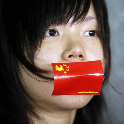 A woman tapes a version of the Chinese flag over her mouth in a speech freedom rally. The Communist Party has aired concerns over the 'overuse' of foreign words. Photo: EPA