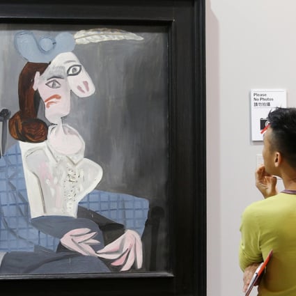 A visitor to Art Basel admires Picasso's Femme dans un Fauteuil (Woman in an Armchair) at the Convention and Exhibition Centre. Photo: K.Y. Cheng
