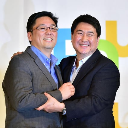 Daum's chief Choi Sae-hoon (left) and his counterpart at Kakao, Lee Sir-goo, announce their merger in Seoul yesterday. Photo: AFP