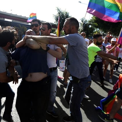 Police restrain a man who attacked gay pride marchers. Photo: AFP