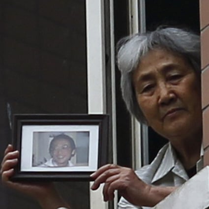 Zhang Xianling holds a photo of her son Wang Nan. Photo: Reuters