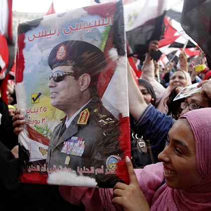  A woman holds a poster of Abdel- Fattah el-Sisi  at Tahrir Square in Cairo on Tuesday. Photo: Xinhua