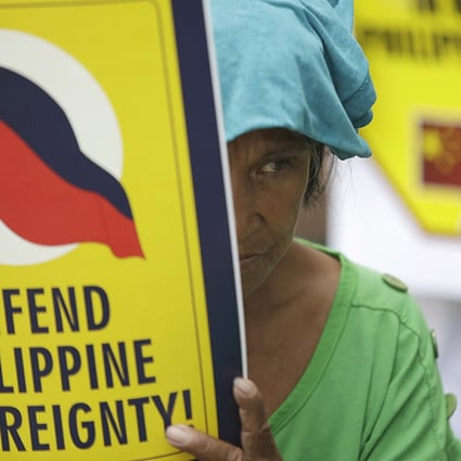 A protester displays a placard during a rally in front of the Chinese Consulate at the financial district of Makati city, east of Manila, Philippines on Friday May 16. photo: AP