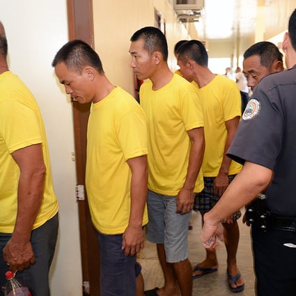 A Philippine prison guard escorts nine arrested Chinese fishermen as they arrive at a courtroom for a pre-trial in Puerto Princesa City, Palawan. Photo: AFP