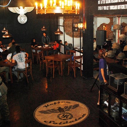 A Nazi swastika insignia sign on the floor decorates the interior of the reopened SoldatenKaffee in Bandung, western Java on Saturday. Photo: AFP