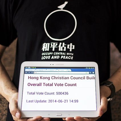 Occupy Central co-organiser Chan Kin-man poses with a tablet showing the number of votes twenty-six hours after their unofficial referendum in Hong Kong. Photo: Reuters