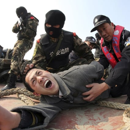 Paramilitary policemen and police officers "arrest" a man acting as an attacker with a knife during an anti-terrorism drill in Rugao, Jiangsu province. Photo: Reuters