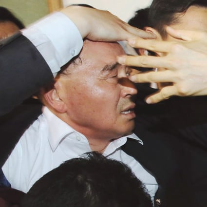 South Korean Prime Minister Chung Hong-won is shielded by bodyguards from angry relatives of Sewol ferry passengers in April. Photo: AP
