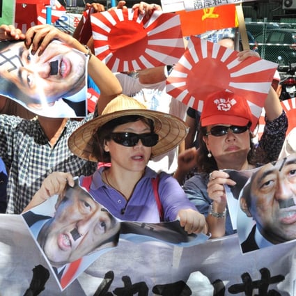 Protesters chant slogans, display Japanese military flags and portraits of Prime Minister Shinzo Abe in Taipei. Photo: AFP