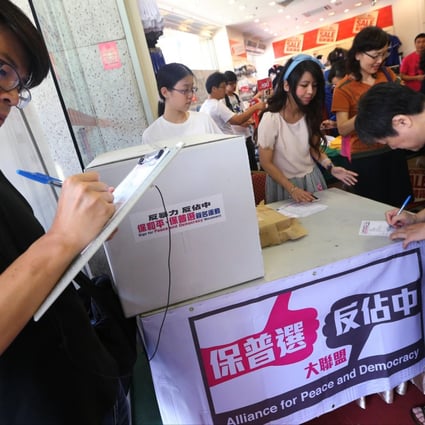 People sign petitions at the Yue Hwa Chinese Products Emporium in Jordan, one of 468 stations across the city. Photo: David Wong