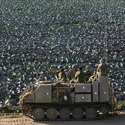 Israeli soldiers ride in an armoured personnel carrier next to a cabbage field near the Gaza Strip. Photo: Reuters