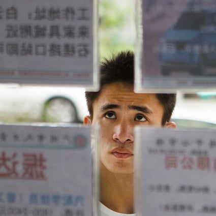 A job seeker looks at recruitment advertisements at a labour market in Guangzhou. Photo: Reuters
