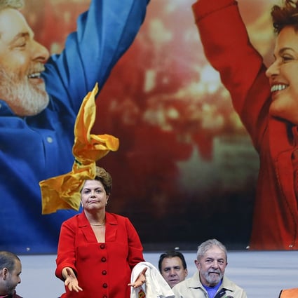 Former Brazilian leader Luiz Ignacio Lula da Silva (second right) watches as Brazil's President Dilma Rousseff catches a shirt thrown to her by a supporter during an election campaign rally in Sao Paulo, Brazil on Thursday. Photo: AP