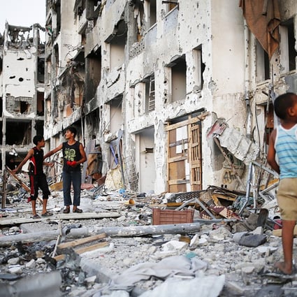 Palestinian boys play among the rubble hours before a 72-hour ceasefire between Israel and Hamas will come to an end in the northern Gaza Strip. Photo: EPA
