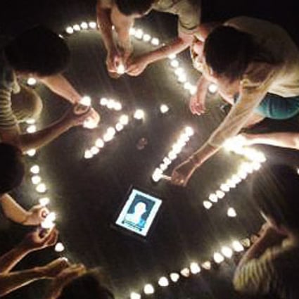 Members of the Shenzhen Chunfeng Labour Disputes Centre participate in a candlelit vigil for Zhou Jianrong, a migrant worker who committed suicide on July 17, 2014. Photo: SCMP Pictures