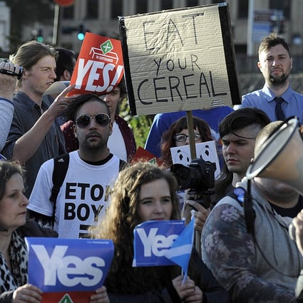 Protesters hold Scottish independence referendum banners from the 'Yes' campaign outside the venue where Britain’s Prime Minister David Cameron was to address the CBI Scotland Annual Dinner in Glasgow on August 28. Photo: AFP