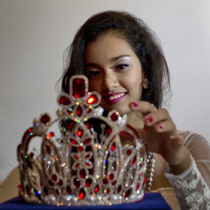 May Myat Noe touches the crown she allegedly ran away with as she holds a press conference to clear her name. Photo: AP
