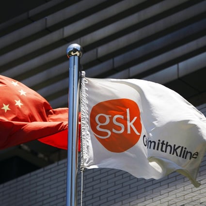 A flag bearing the logo of GlaxoSmithKline (GSK) flutters next to a Chinese national flag outside a GlaxoSmithKline office building in Shanghai. Photo: Reuters 