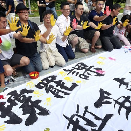 Former students put their hand prints on a banner at Tamar Park backing the class boycott by students. Photo: K.Y. Cheng