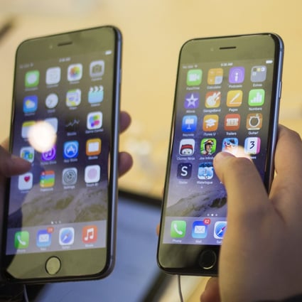 A customer holds an iPhone 6 (right) and iPhone 6 Plus. Photo: Reuters