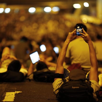 A protester takes pictures of fellow demonstrators with his mobile phone. Photo: Reuters