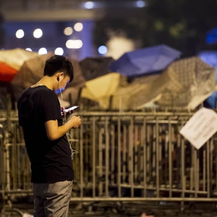 A pro-democracy demonstrator checks his phone in Hong Kong. WeChat is reportedly blocking messages about the protests. Photo: AFP