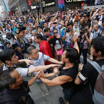 Pro-democracy demonstrators clash with anti-Occupy protesters in Mong Kok yesterday. Mainland media warn of economic losses to the city. Photo: Sam Tsang